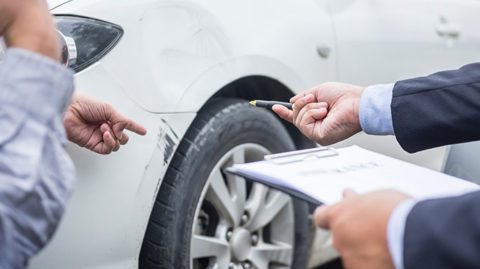 insurance adjuster inspecting car damage