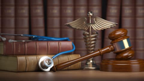 Gavel, stethoscope and caduceus sign on books