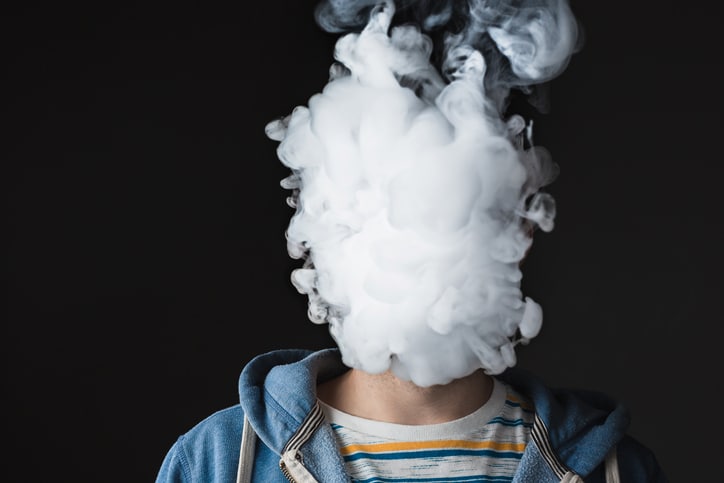 Obscured face of vaping young man