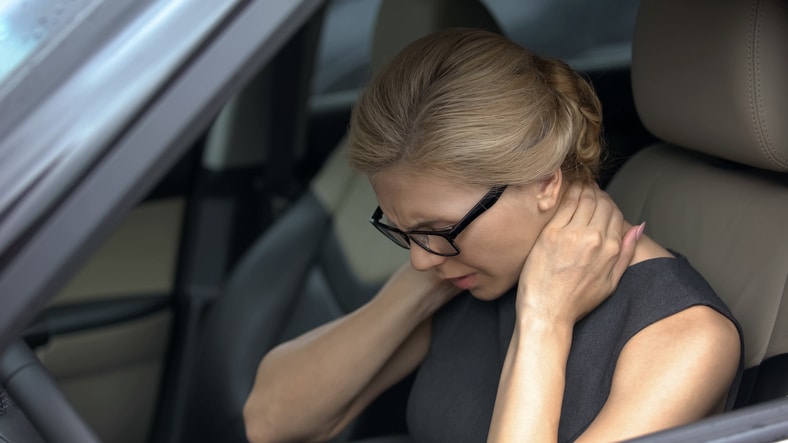 women with painful neck in car