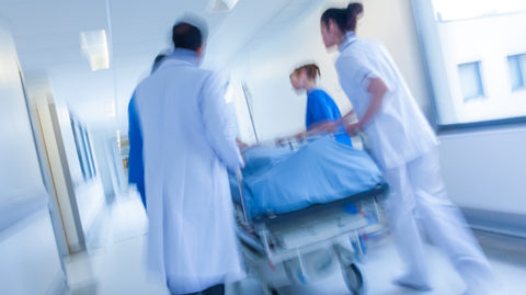 doctors and nurses pushing patient in a bed