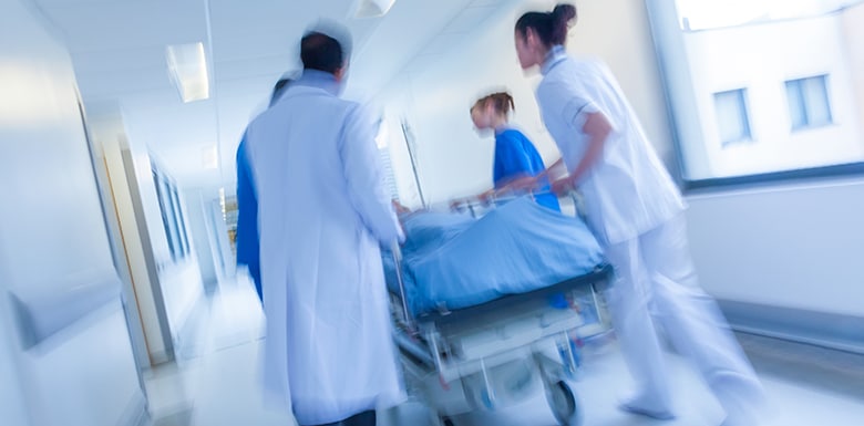 doctors and nurses pushing patient in a bed