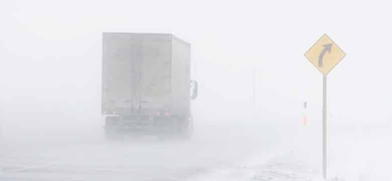 Semi truck driving in snow storm