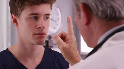 A doctor running eye tests on a man