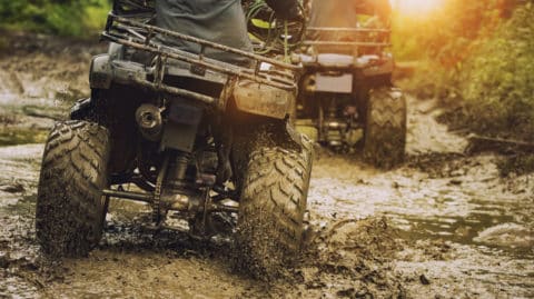 ATVs being ridden through the mud