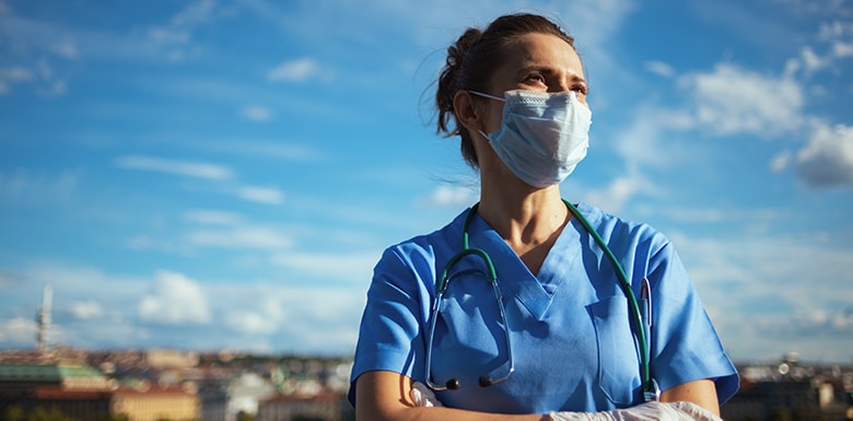 Female doctor wearing mask in front of blue sky