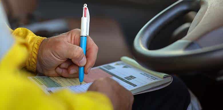 Man filling out crash report at driving wheel