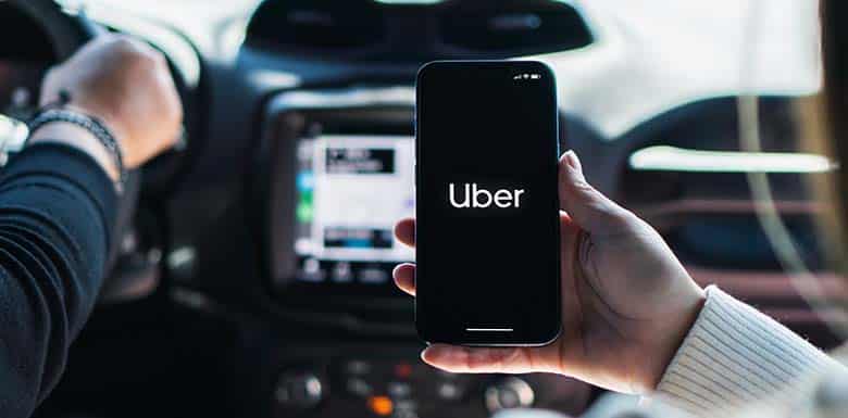 Woman using uber on her phone while in backseat of car