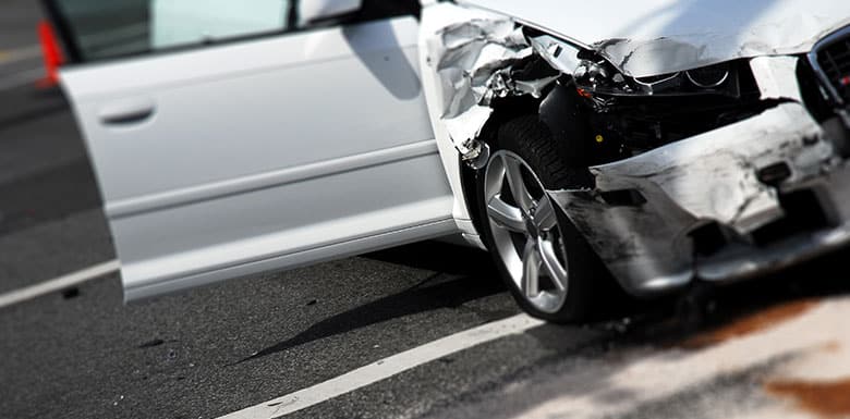 Front of car smashed in after it was hit by a speeding car